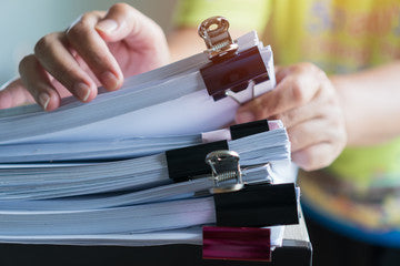 Hands with a stack of paper in bundles with paper clips